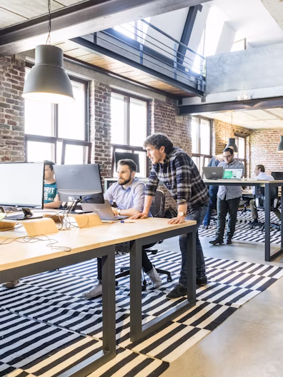 Two employees reviewing a laptop