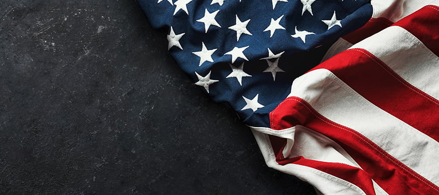 An American flag laying on a black stone